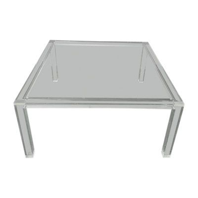 a clear glass table sitting on top of a white floor