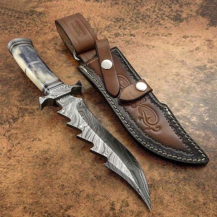 two knives are laying next to each other on a table with a knife sheath in it