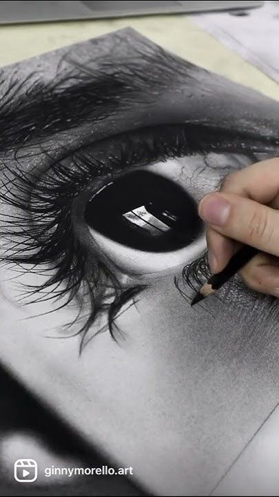 a person drawing an eye with a pencil