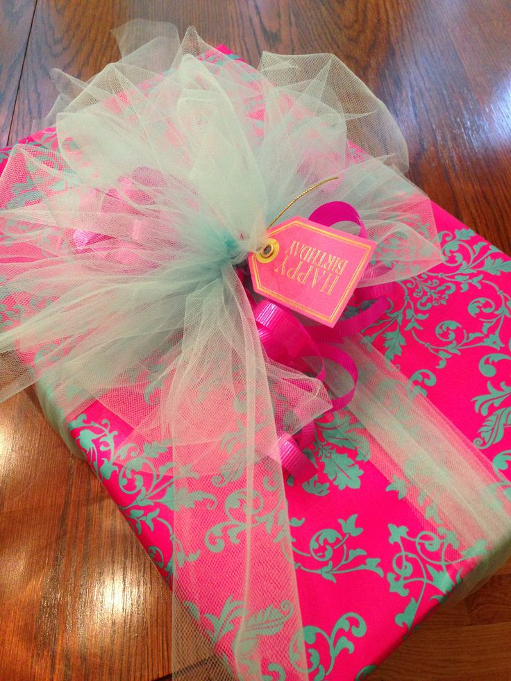 a present wrapped in pink and green with a bow