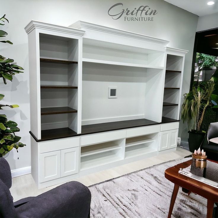 a living room filled with furniture next to a wall mounted book shelf and potted plant