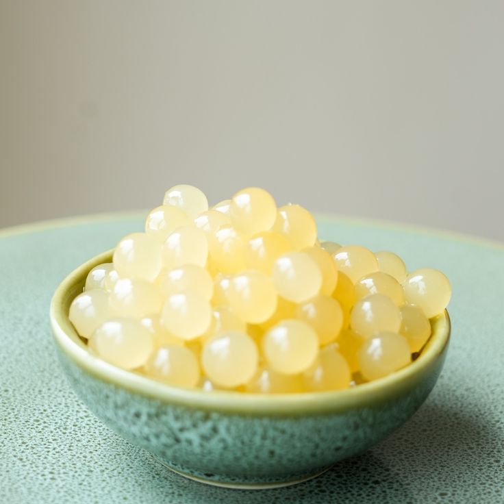 a small bowl filled with yellow candies on top of a table