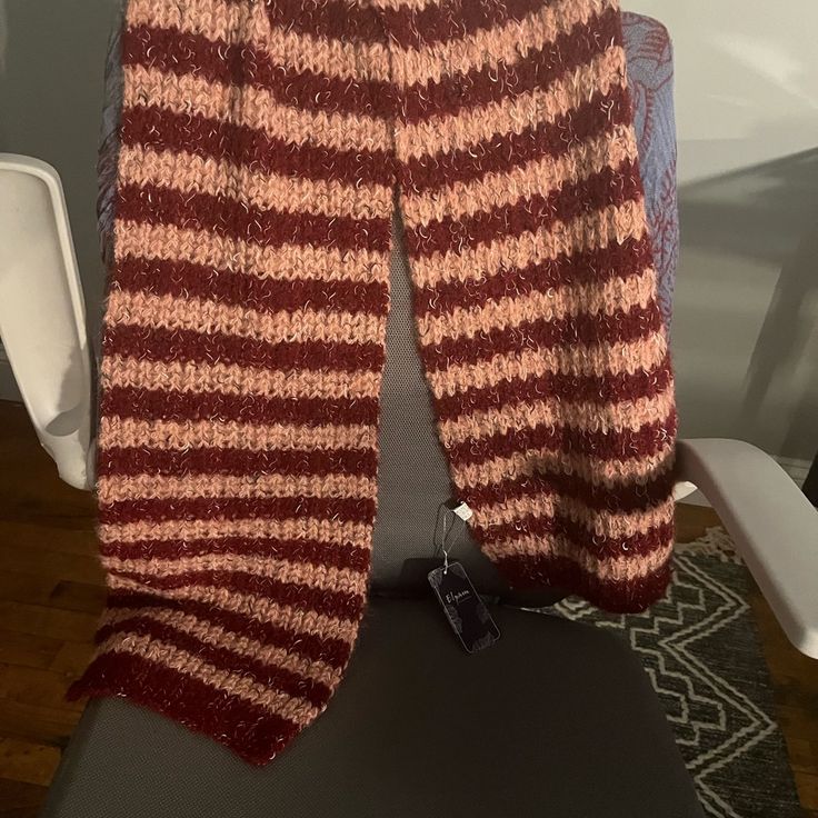 a red and white striped sweater hanging on a chair