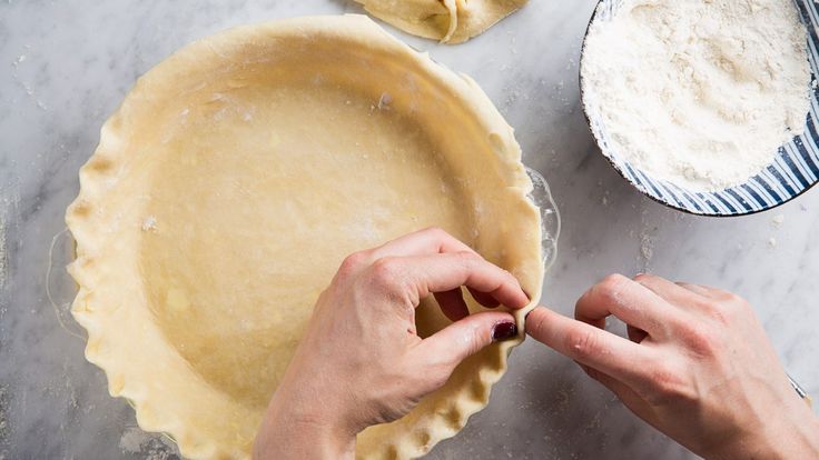 the person is making pie dough on the table