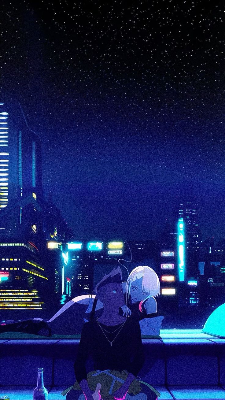 two people sitting at a table in front of a cityscape with neon lights