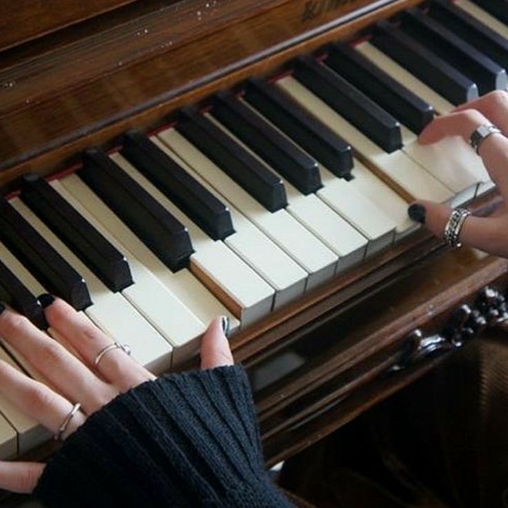 two hands are playing the piano with their fingers and thumbnails, while another hand is on the keys