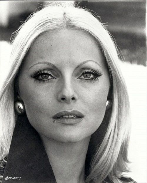 a black and white photo of a woman with long blonde hair, wearing large earrings