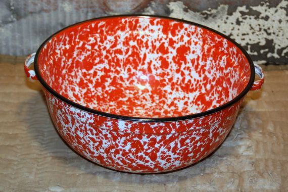 a red and white bowl sitting on top of a wooden table