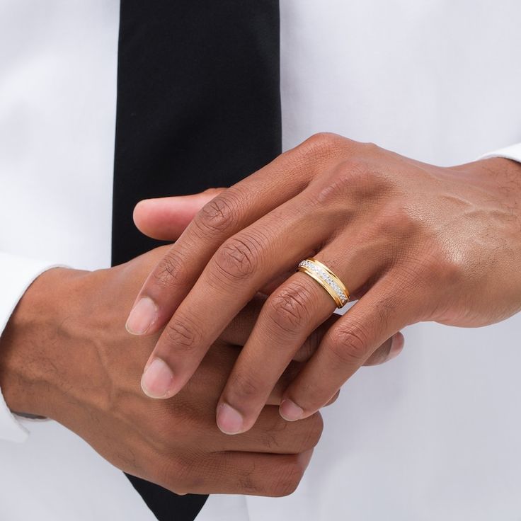 two hands holding each other while wearing wedding rings