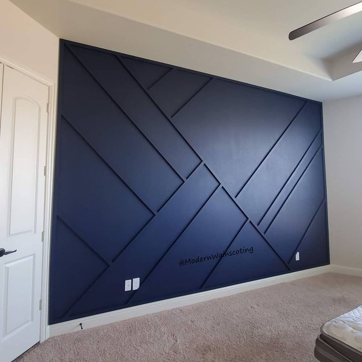 an empty bedroom with blue walls and carpet