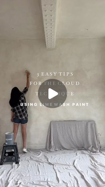 a woman is painting the ceiling in her bedroom