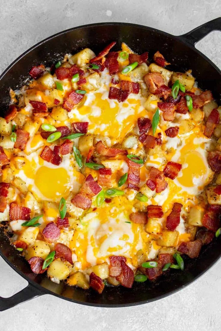 a skillet filled with eggs, bacon and cheese