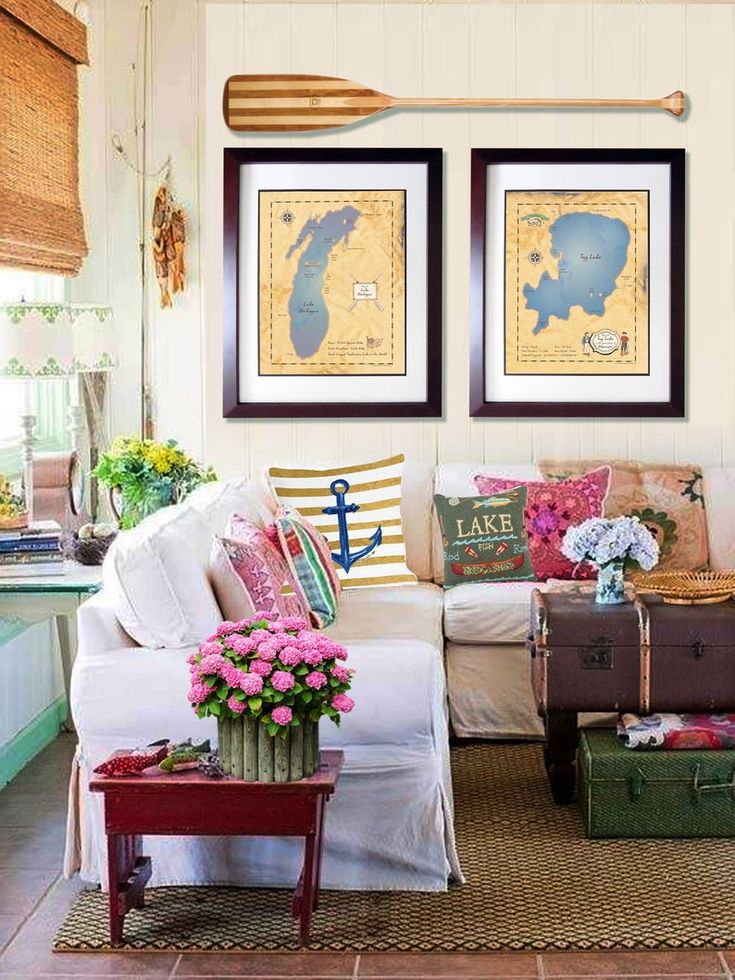 a living room filled with lots of furniture and flowers on top of a rug in front of two framed pictures