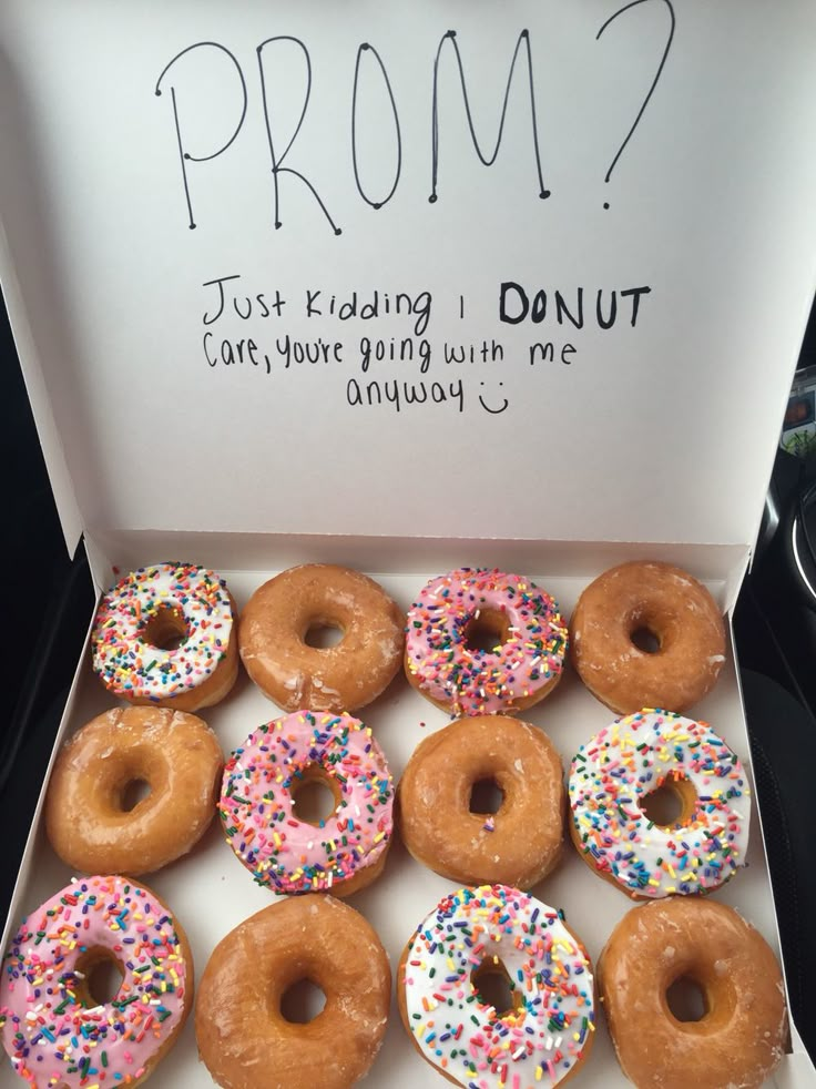 a dozen donuts in a box with sprinkles on them are shown