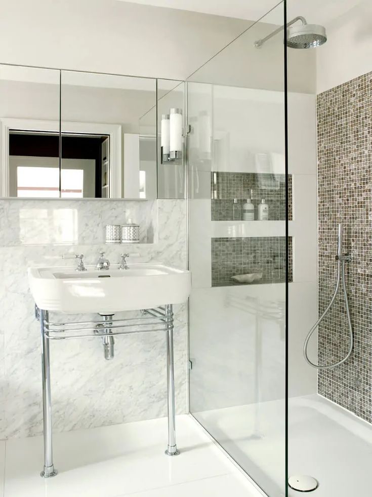 a bathroom with a sink, mirror and bathtub in the shower stall is shown