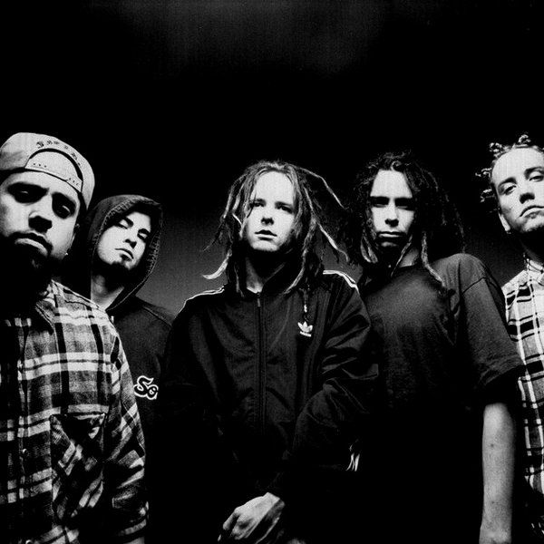 a group of young men standing next to each other in front of a black background