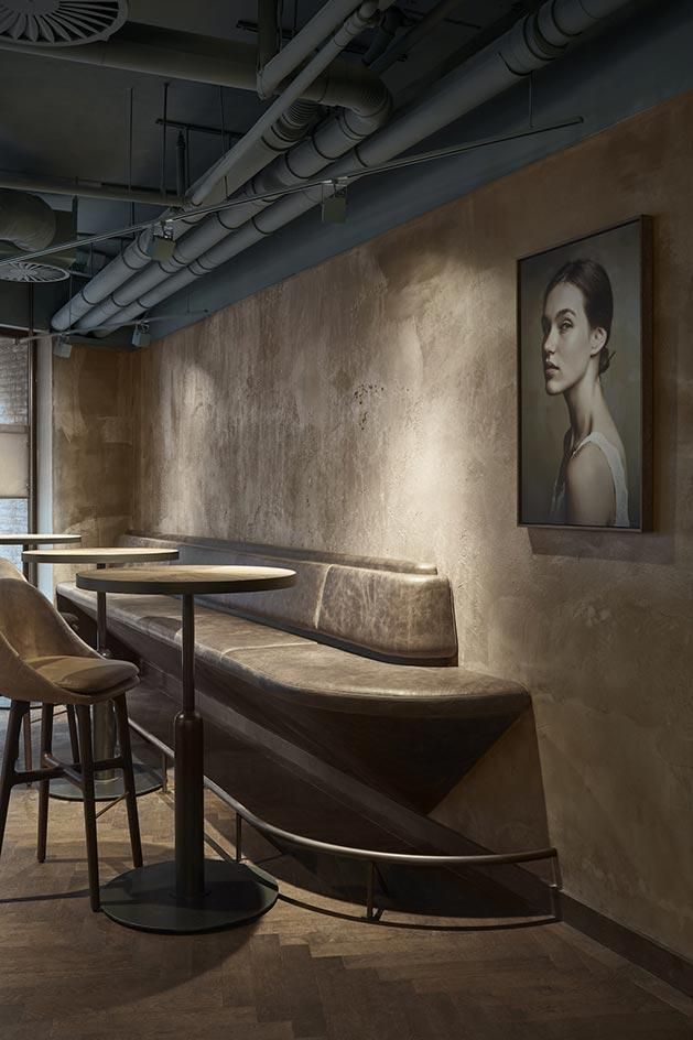 an empty restaurant with tables and stools next to a painting hanging on the wall