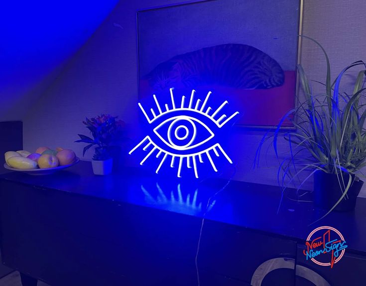 a neon sign with an eye on it in the middle of a room next to a potted plant