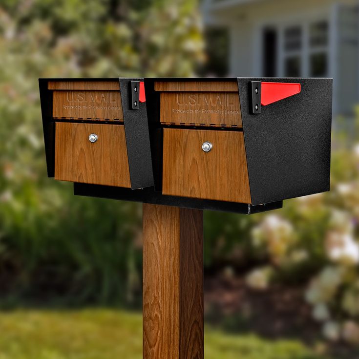 two mailboxes are attached to a post in front of a house