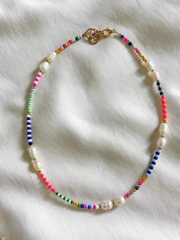 This multicolor freshwater pearl necklace is the perfect necklace for the daytime. It's unique in style and pattern. This necklace is 15 inches in length with an inch for adjustment. All jewelry comes with a Beaded by Sandy care card explaining the best ways to take care of your jewelry.  Designed and handmade just for you in the USA. Personal message from the owner of Beaded by Sandy: Hello! Thank you so much for the support and continuous love. I am a teenager from South Texas who loves making jewelry and creating art. I started my small business back in 2019. I have participated in local market events and have made Beaded by Sandy known in my small town. I am thankful for my followers, supporters, and family for the genuine love! Please message my Instagram for any questions.   IG: @bea Beaded Necklace Colorful, Fun Beaded Necklaces, Diy Bead Necklace Ideas, Multicolor Beaded Necklace, Beaded Necklace Inspiration, Handmade Necklaces Diy, Small Beaded Bracelets Diy, Beaded Jewelry Inspiration, Bead Color Patterns