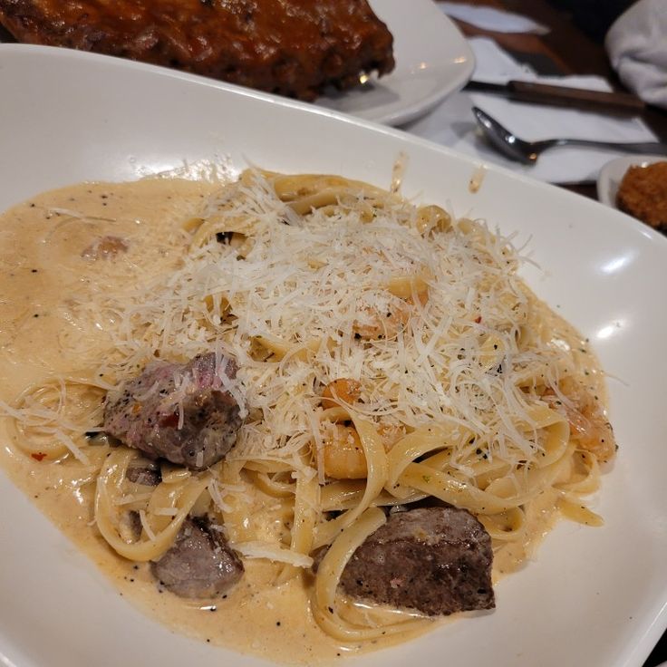 a white plate topped with pasta and meatballs