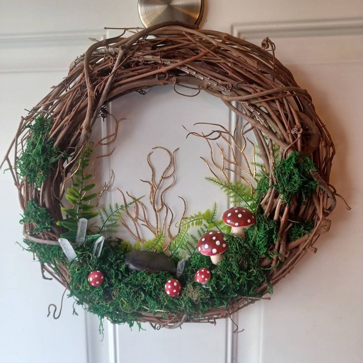 a wreath with mushrooms and ferns is hanging on the wall