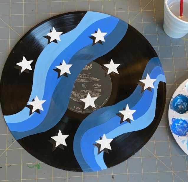 a record sitting on top of a table next to a plate with stars painted on it