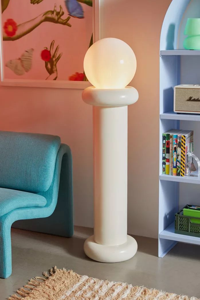 a white lamp sitting on top of a table next to a blue chair