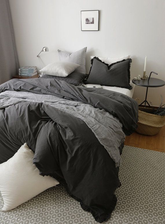 a bed with black and white comforters in a bedroom