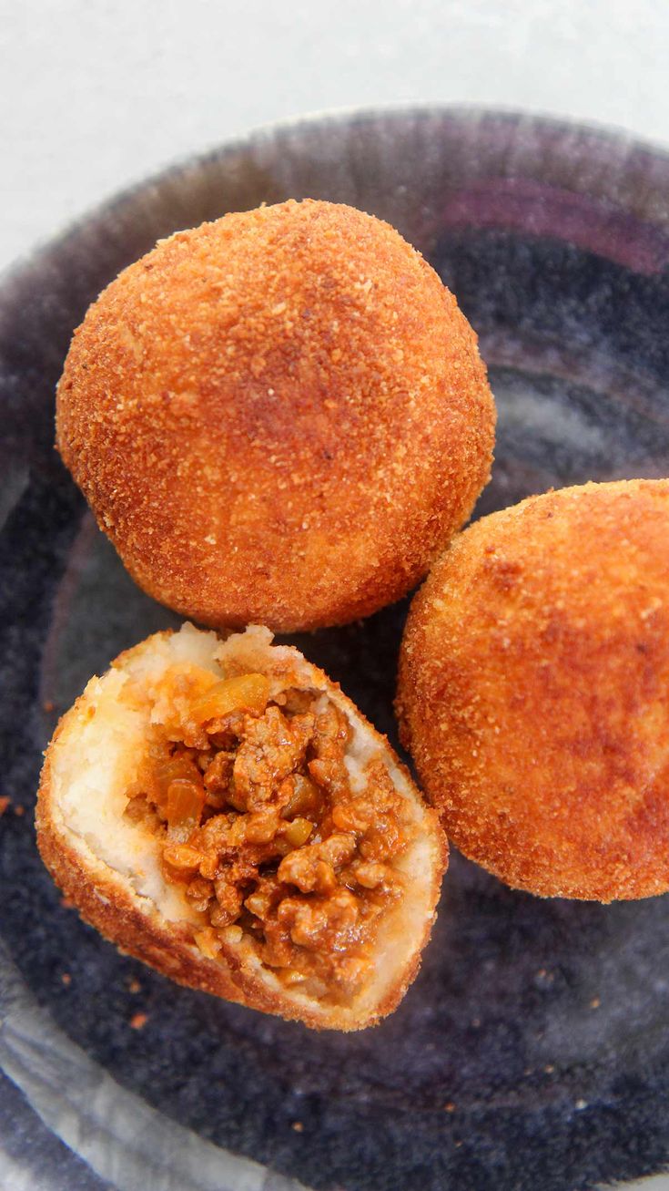 two fried food items on a black plate