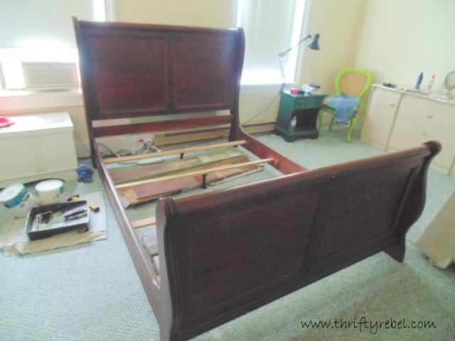 a bed with wooden slats is shown in the middle of a room that has several other items on the floor