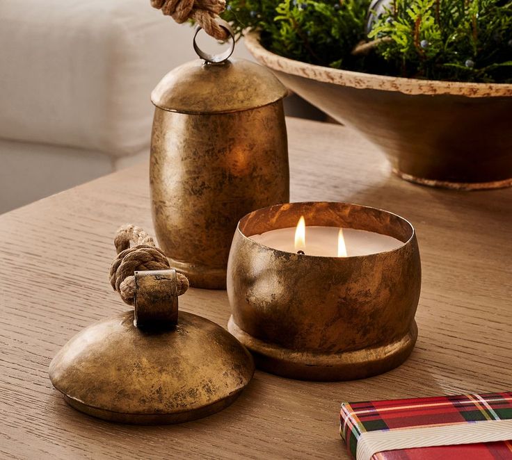 a candle is sitting on a table next to two vases with plants in them