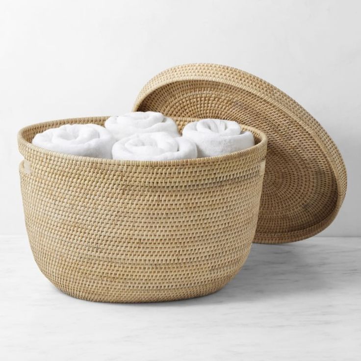 two woven baskets with white towels in them