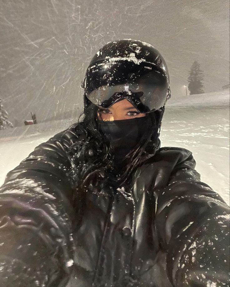 a man wearing a black jacket and ski goggles in the snow