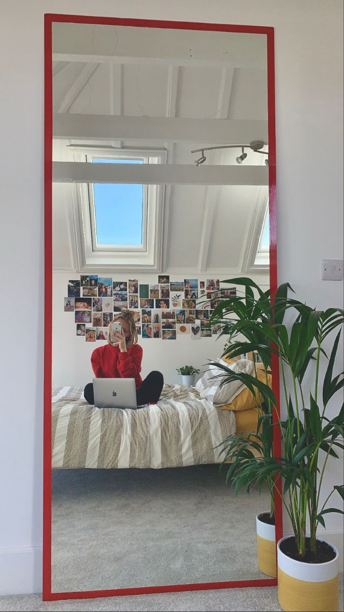 a person sitting on a bed in front of a mirror