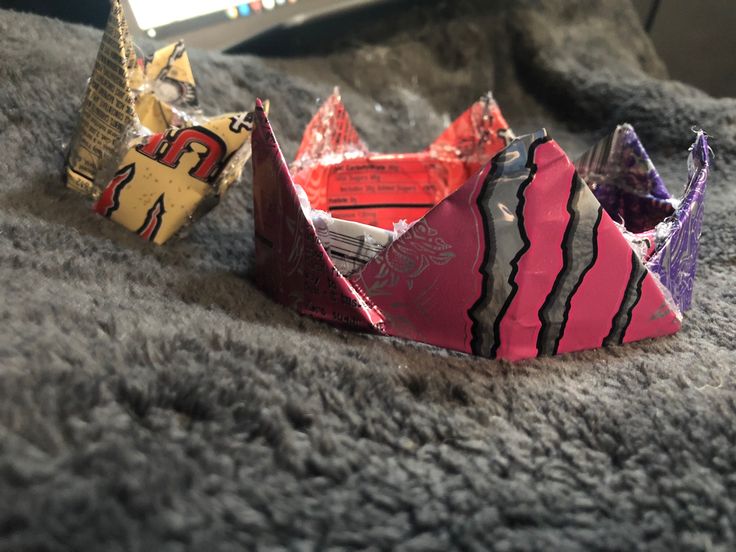 three origami crowns sitting on top of a gray blanket