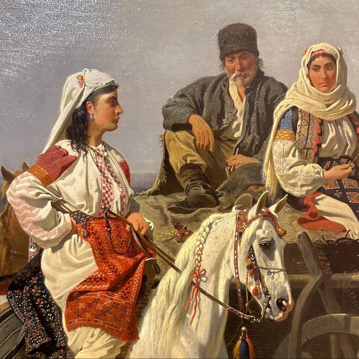 two men and a woman sitting on top of a white horse next to each other