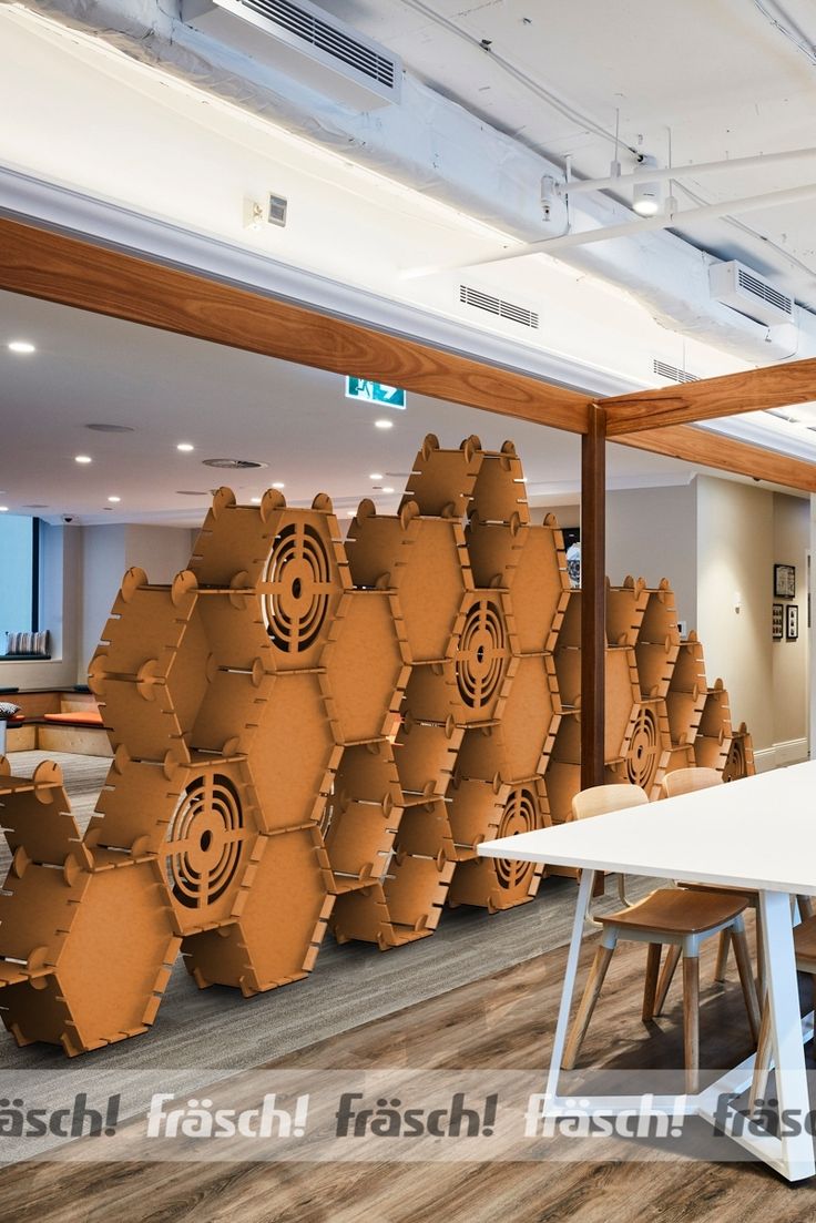 an office with large stacks of brown boxes on the wall and tables in front of them