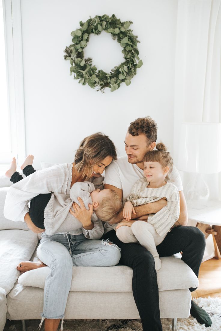 a man, woman and child sitting on a couch with their arms around each other