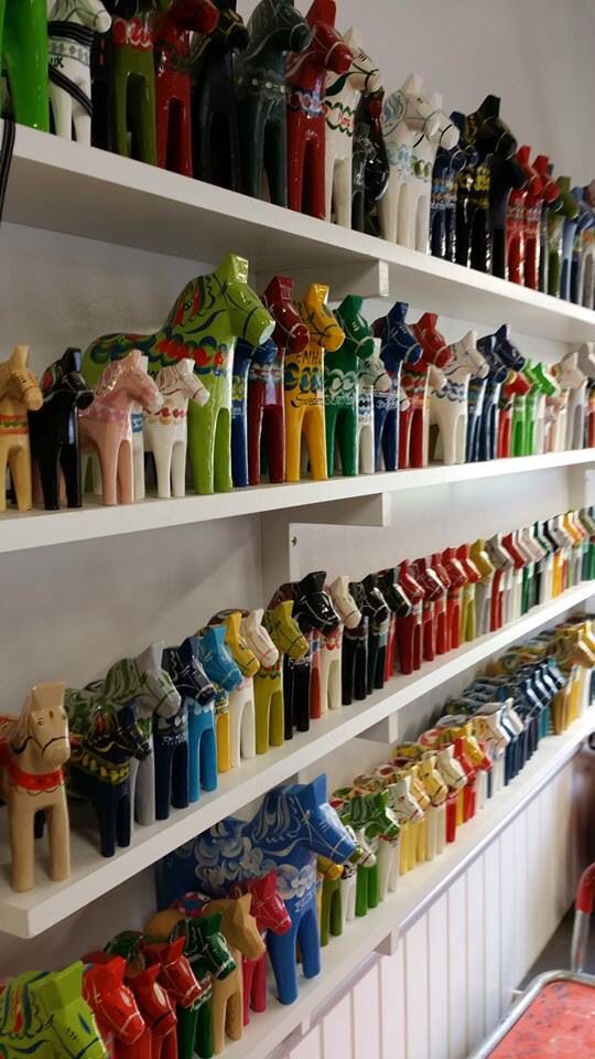 many colorful vases are on shelves in a store