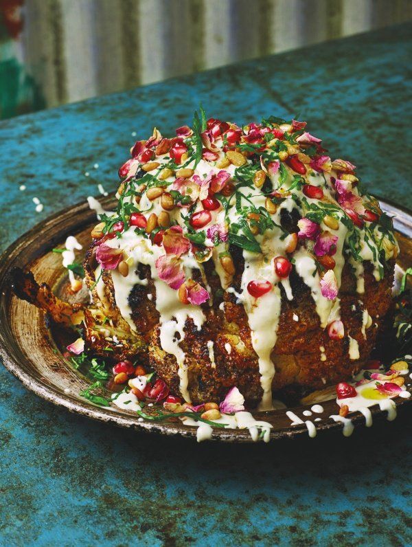 a plate filled with food on top of a blue countertop next to a knife and fork