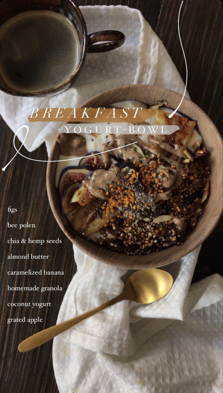 a wooden bowl filled with food on top of a table next to a cup of coffee