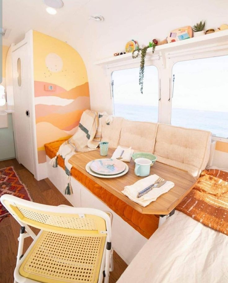 there is a table and chairs in the living room by the window that overlooks the ocean