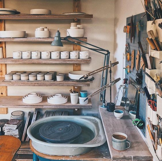 a pottery shop with lots of pots and pans on the wall, shelves holding various types of pottery