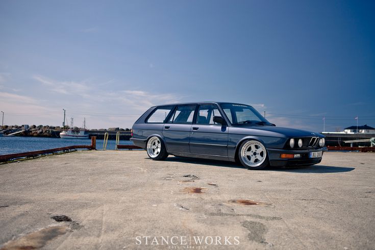 a blue station wagon parked in front of the water