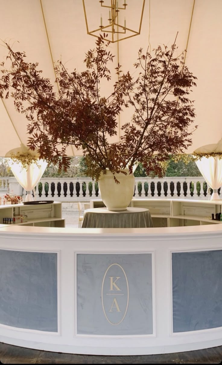 a vase filled with flowers sitting on top of a counter under a chandelier