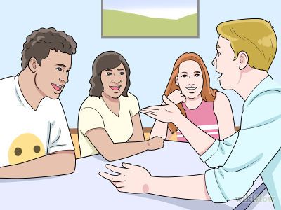 a group of people sitting around a table talking to each other and smiling at one another