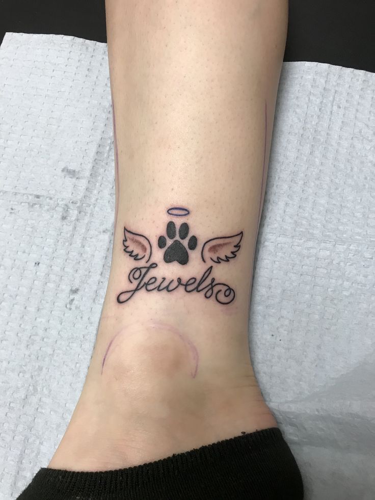 a person with a dog's paw and name tattoo on their foot that reads, jevree