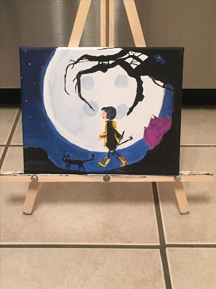 an easel with a painting of a boy and cat on it in front of a full moon