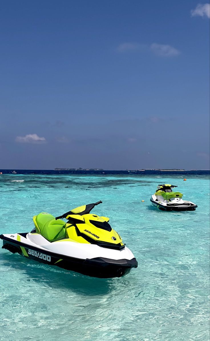 two jet skis are in the clear blue water